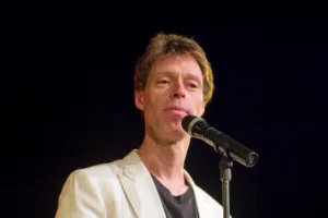 Martin Schneider Artikelbild mit Retro-Mikrofon auf Bühne in hochwertigem Editorial-Stil