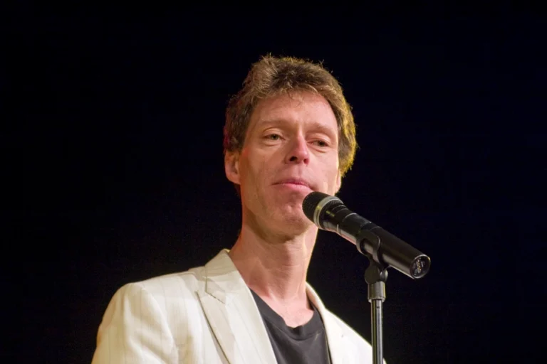 Martin Schneider Artikelbild mit Retro-Mikrofon auf Bühne in hochwertigem Editorial-Stil
